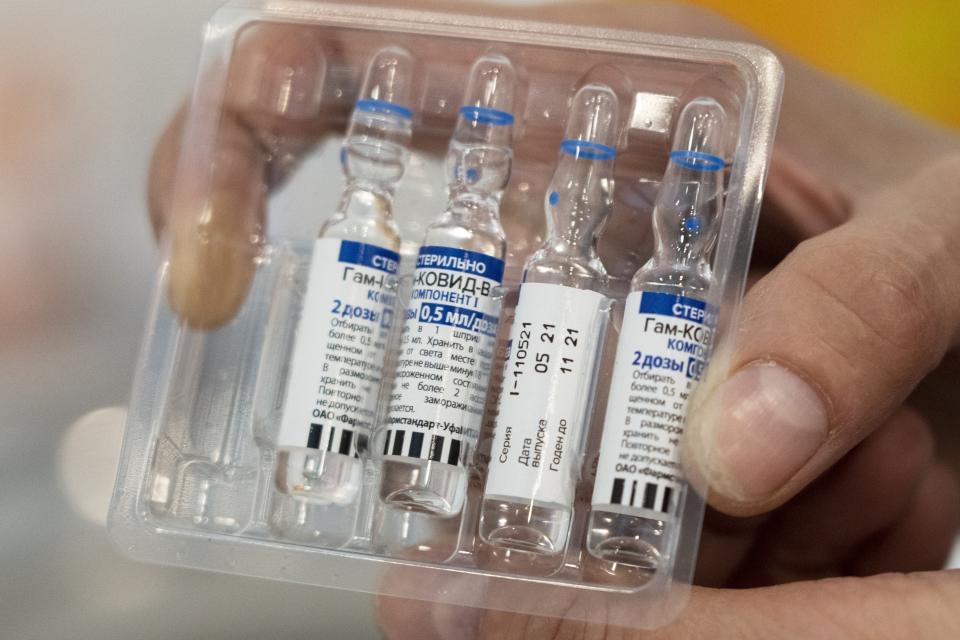 FILE - In this July 1, 2021, file photo, a medical worker shows vials with Russia's Sputnik V coronavirus vaccine in a medical room, at a vaccination center in the GUM, State Department store, in Red Square in Moscow, Russia. Russians are flocking to Serbia to receive Western-approved COVID-19 shots. Although Russia has its own vaccine known as Sputnik V, the shot has not been approved by international health authorities. (AP Photo/Pavel Golovkin, File)