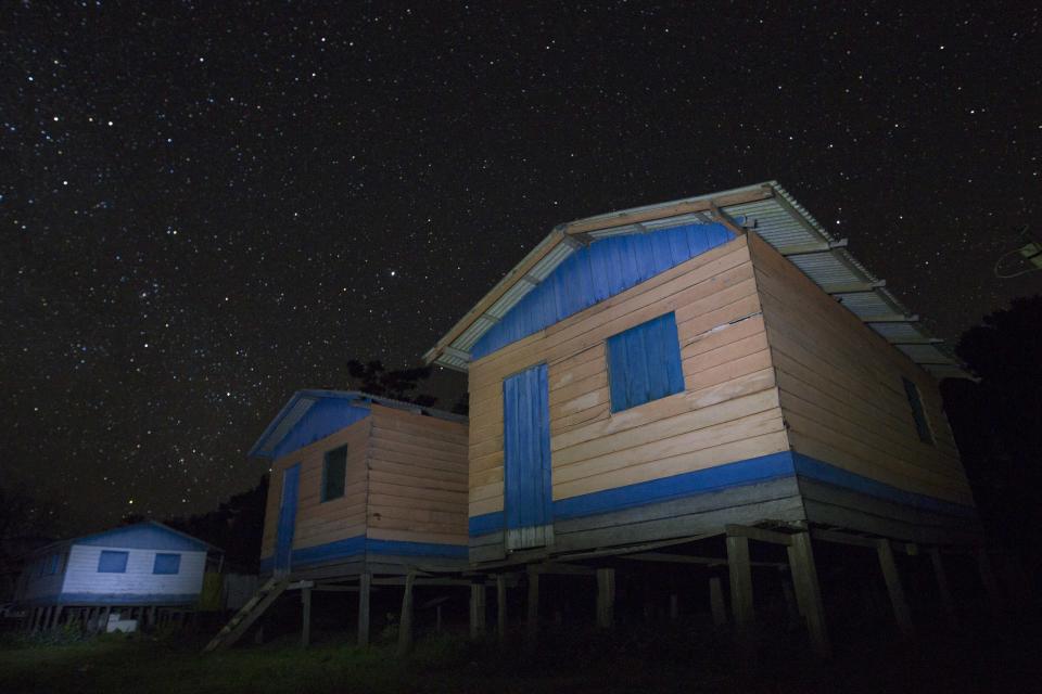 A night view of the Sao Raimundo do Jaraua community along the edge of a tributary of the Solimoes river, one of the main tributaries of the Amazon, where adults fish for arapaima or pirarucu, the largest freshwater fish species in South America and one of the largest in the world, in the Mamiraua nature reserve near Fonte Boa about 600 km (373 miles) west of Manaus, November 27, 2013. Catching the arapaima, a fish that is sought after for its meat and is considered by biologists to be a living fossil, is only allowed once a year by Brazil's environmental protection agency. The minimum size allowed for a fisherman to keep an arapaima is 1.5 meters (4.9 feet). Picture taken November 27, 2013. REUTERS/Bruno Kelly (BRAZIL - Tags: ENVIRONMENT SOCIETY ANIMALS) ATTENTION EDITORS: PICTURE 02 OF 22 FOR PACKAGE 'FISHING FOR BRAZIL'S FOSSILS'. TO FIND ALL IMAGES SEARCH 'ARAPAIMA KELLY'