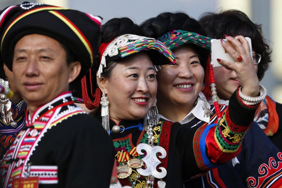 Minority delegates take a selfie as they arrive outside the Great Hall of the People to attend the opening session of the annual National People's Congress in Beijing, Sunday, March 5, 2017. China's top leadership as well as thousands of delegates from around the country are gathered at the Chinese capital for the annual legislature meetings. (AP Photo/Andy Wong)