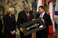 Canada's Prime Minister Stephen Harper (C) receives a key of the Knesset, Israel's parliament, from Knesset speaker Yuli Edelstein (R) during his visit at the Knesset in Jerusalem January 20, 2014. Harper is on a four-day visit to Israel and the Palestinian Territories. REUTERS/Ronen Zvulun (JERUSALEM - Tags: POLITICS)