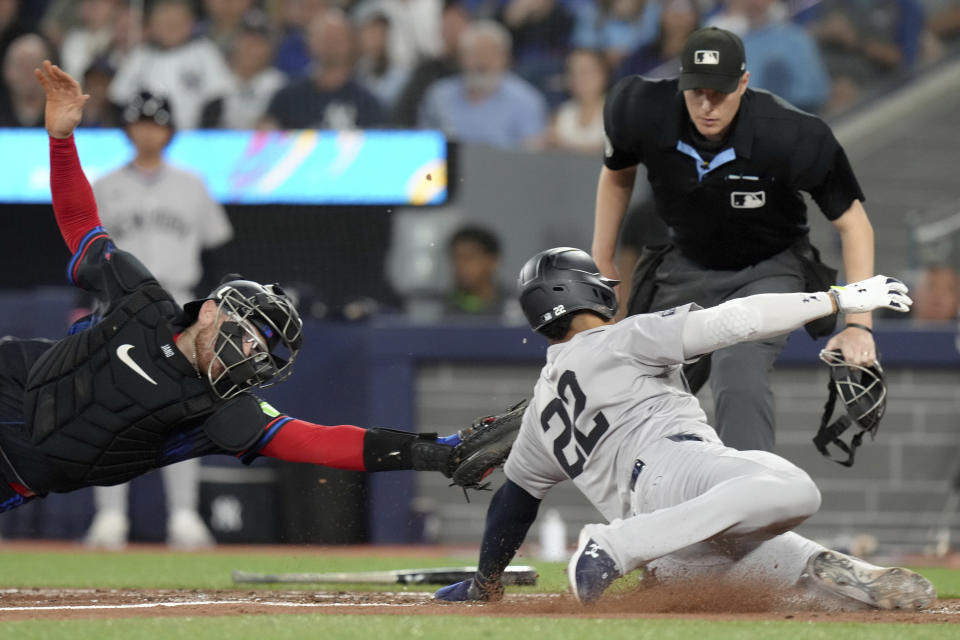 New York Yankees outfielder Juan Soto (22) slides safe into home as Toronto Blue Jays catcher Danny Jansen (9) fails to make the tag during fourth inning American League MLB baseball action in Toronto, Friday, June 28, 2024. THE CANADIAN PRESS/Chris Young/The Canadian Press via AP)