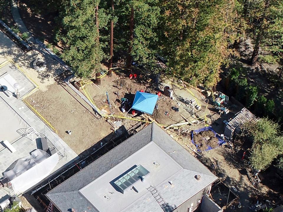 A mansion is under investigation by police after a car was found buried on the property the day before, in Atherton, Calif., Friday, Oct. 21, 2022. Three decades after a car was reported stolen in Northern California, police are digging the missing convertible out of the yard of a $15 million mansion built by a man with a history of arrests for murder, attempted murder and insurance fraud.
