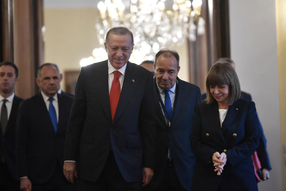 Greece's President Katerina Sakellaropoulou, right, walks with her Turkish counterpart Recep Tayyip Erdogan, left, before their meeting at the Presidential Palace in Athens, Greece, Thursday, Dec. 7, 2023. Erdogan arrived in Greece on a visit designed to set the historically uneasy neighbors on a more constructive path and help repair strained his country's strained relationship with the European Union. (AP Photo/Michael Varaklas)
