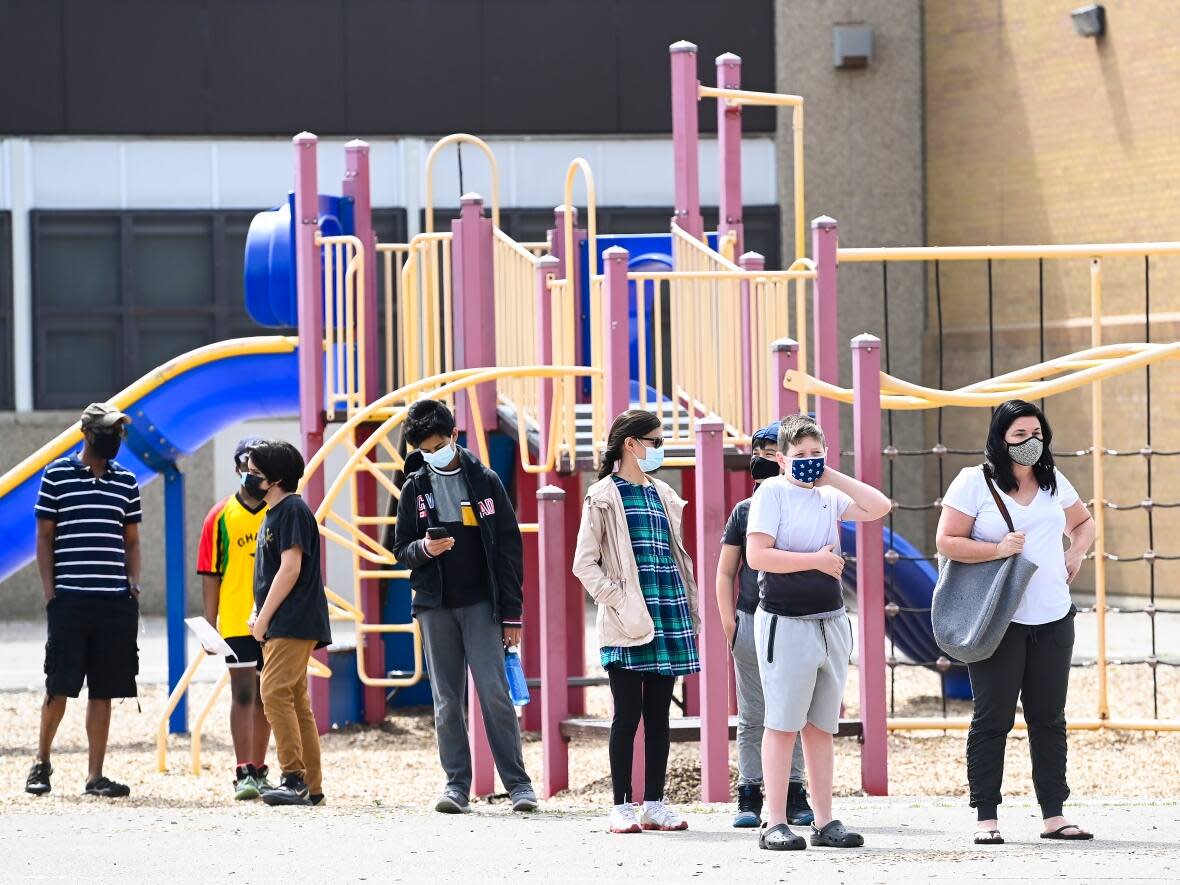 Families and youth aged 12 and older line up for a COVID-19 vaccine at Gordon A Brown Middle School in Toronto Wednesday May 19, 2021. Health Canada is currently considering whether to approve a pediatric version of Pfizer-BioNTech's COVID-19 vaccine for kids age five to 11 years old. (Nathan Denette/The Canadian Press - image credit)