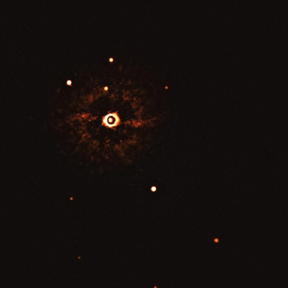 Un sistema con dos planetas captados mediante imagen directa: TYC 8998-760-1. La estrella aparece en el centro afectada por artefactos causados por el sistema empleado para atenuar su brillo aparente, mientras que los dos planetas aparecen abajo a la izquierda, alineados. Los otros puntos son estrellas de fondo. La proeza es posible en este caso porque la estrella está cerca del Sol, y sus planetas son enormes y están muy alejados de ella. ESO/Bohn et al.