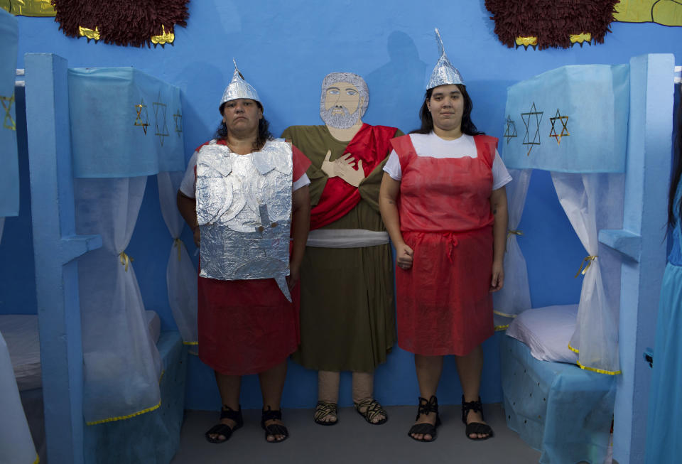 Female inmates dressed as guards pose for a photo during Nelson Hungria Prison's annual Christmas event for inmates and jail staff in Rio de Janeiro, Brazil, Thursday, Dec. 13, 2018. Inmates serving time for offenses from burglary to homicide spent weeks decking out their cell blocks with handmade Christmas decorations and planning Bible related performances. (AP Photo/Silvia Izquierdo)