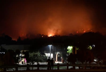 People watch as fast-moving wildfire, that destroyed homes driven by strong wind and high temperatures forcing thousands of residents to evacuate, burns in Goleta, California, U.S., early July 7, 2018. REUTERS/Gene Blevins