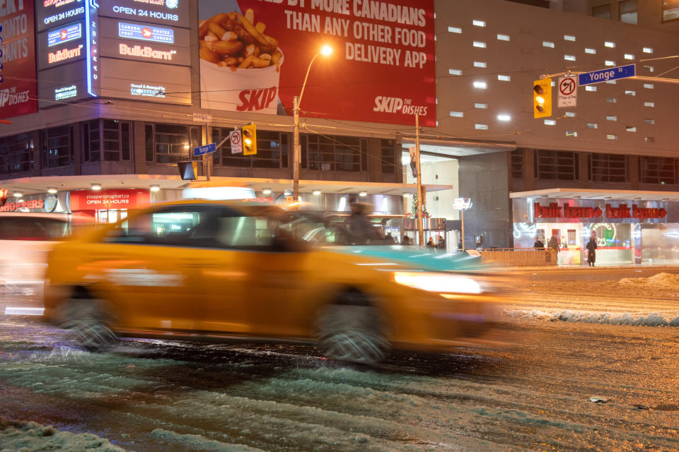 Toronto, Ontario, Canada-December 1, 2019: Motion blur of a Beck Taxi after a snowfall in the downtown district. The company sees increased business during bad weather days.