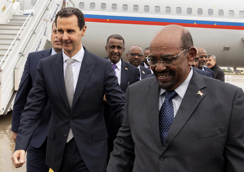 In this photo released by the Syrian official news agency SANA, Syrian President Bashar Assad, left, meets with Sudan's President Omar al-Bashir in Damascus, Syria, Sunday, Dec. 16, 2018 in Damascus. Sudan's president has become the first Arab League leader to visit Syria since a war erupted there nearly eight years ago. Omar al-Bashir was greeted at the Damascus airport Sunday by Syrian President Bashar Assad. Syria was expelled from the 22-member Arab League soon after war broke out in 2011. (SANA via AP)