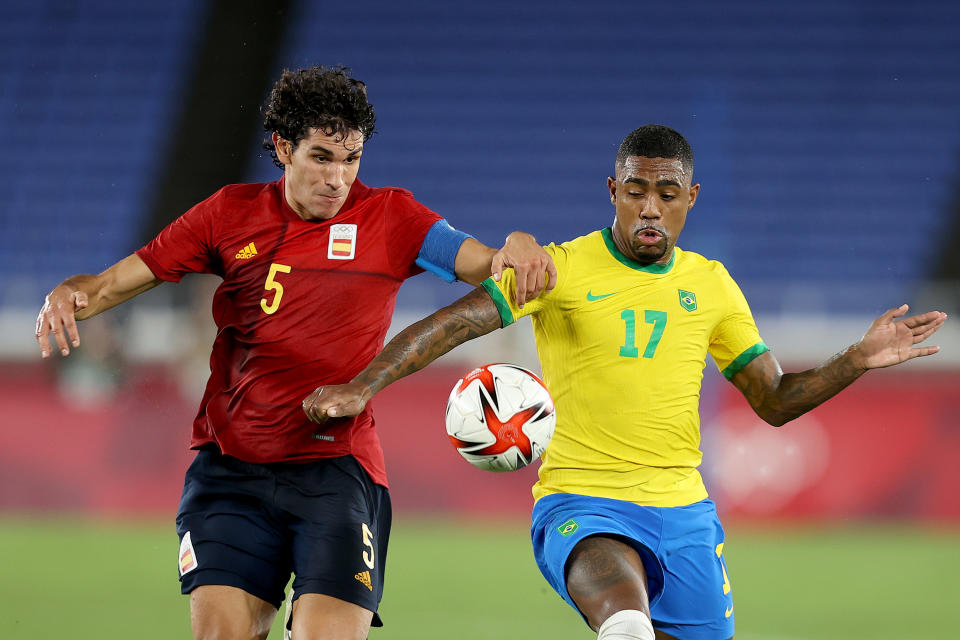 YOKOHAMA, JAPAN - AUGUST 07: Malcom #17 of Team Brazil battles for possession with Jesus Vallejo #5 of Team Spain during the Men's Gold Medal Match between Brazil and Spain on day fifteen of the Tokyo 2020 Olympic Games at International Stadium Yokohama on August 07, 2021 in Yokohama, Kanagawa, Japan. (Photo by Francois Nel/Getty Images)