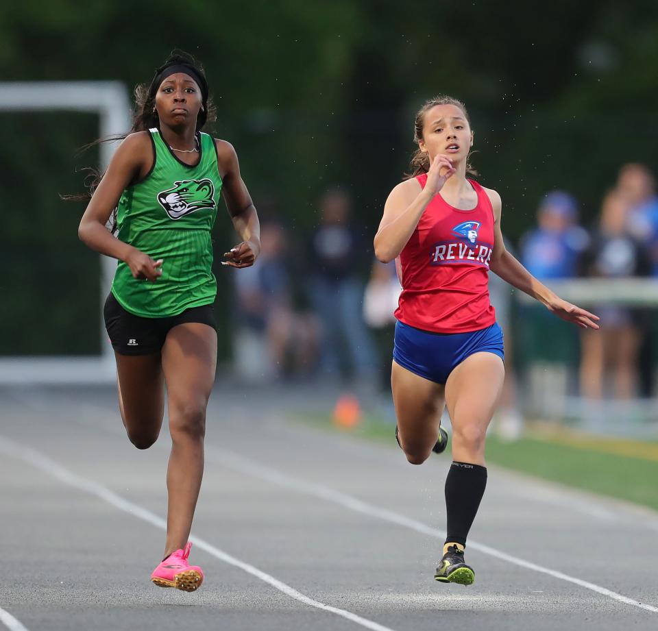 Leah Valentine of Revere, right, runs alongside Kyndall Worth of Bedford in the girls 200 meter dash during the Division I district track meet at Nordonia High School May 17.