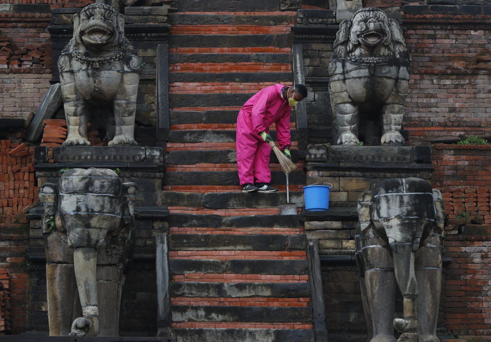 A Nepalese cleaner sweeps the stairs of temple during lockdown in Bhaktapur, Nepal, Tuesday, May 26, 2020. Nepal's lockdown imposed on March 24 to stop the spread of the coronavirus has been extended to June 2. (AP Photo/Niranjan Shrestha)