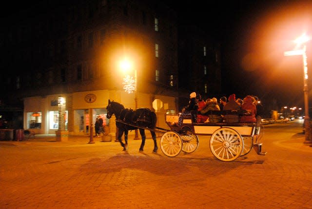 A horse and carriage pulled members of the Ames community through the Main Street Cultural District during Snow Magic in 2014. The tradition showcases downtown businesses and owners, and helps to start the holiday season in Ames. File photo by Julie Ferrell/Ames Tribune