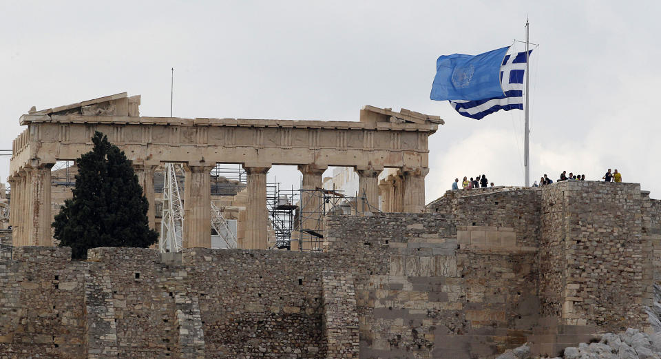 The UN flag waves next to the Greek one on top of Acropolis hill as the temple of Parthenon is seen in the background to mark the 67th United Nations Day in Athens on Wednesday, Oct. 24, 2012. (AP Photo/Dimitri Messinis)