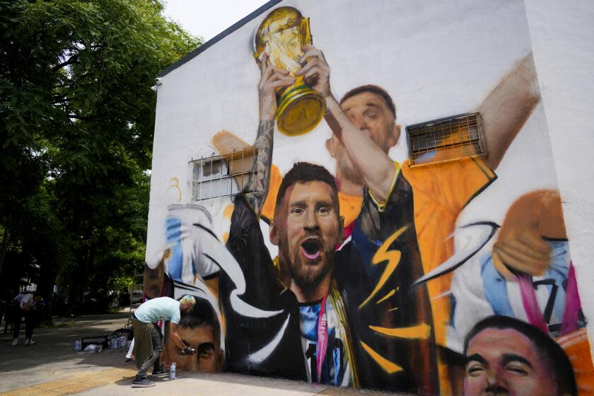 El artista Maxi Bagnasco pinta su mural con la imagen del astro Lionel Messi alzando la Copa de Mundo en Buenos Aires, Argentina, el jueves 22 de diciembre de 2022. (AP Foto/Natacha Pisarenko)