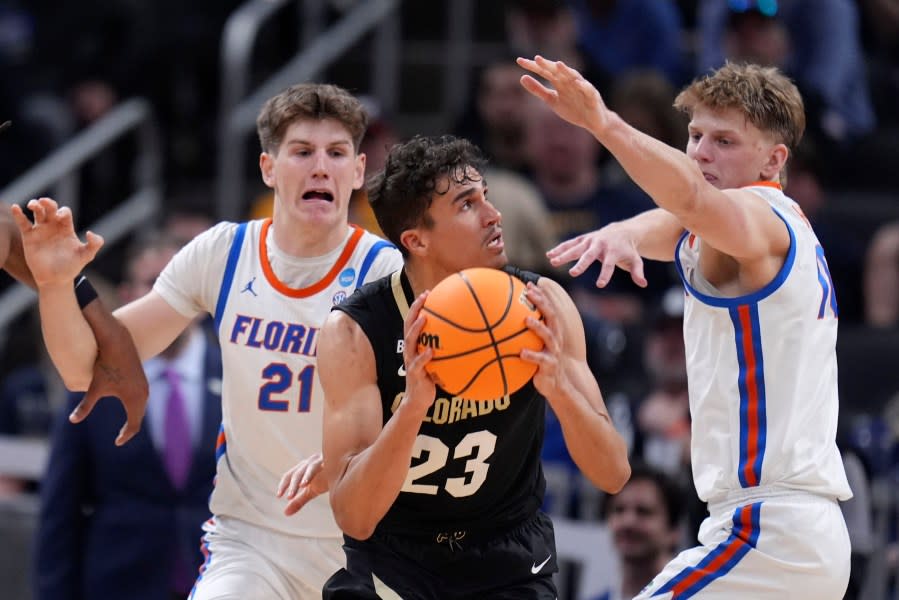 Colorado forward Tristan da Silva (23) drives between Florida forward Alex Condon (21) and forward Thomas Haugh, right, in the first half of a first-round college basketball game in the NCAA Tournament, Friday, March 22, 2024, in Indianapolis, Ind. (AP Photo/Michael Conroy)