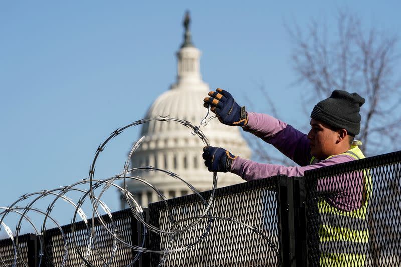 FILE PHOTO: Workers remove razor wire from security fencing near the U.S. Capitol in Washington