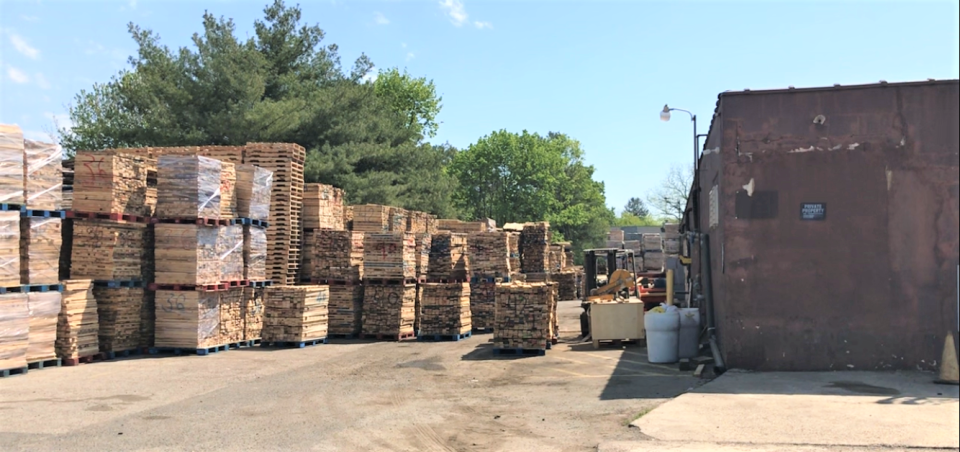 Stores of wooden pallets line the rear of the Independent Freight property at 20 Warrick Avenue in Glassboro. The old factory is used to recycle, make, and distribute pallets. The site is in a residential zone, and neighbors have been complaining. The company is seeking a use variance while at the same time saying it plans to relocate. PHOTO: April 21, 2022.