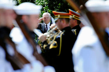 FILE PHOTO: U.S. Defense Secretary Robert Gates (C) salutes as troops perform a march-in-review during his farewell ceremony at the Pentagon in Arlington, Virginia, June 30, 2011. REUTERS/Jonathan Ernst/File Photo