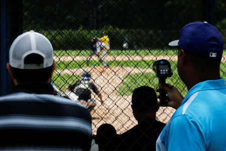 Trainers and scouts look at players during a baseball showcase in Caracas, Venezuela August 22, 2017. REUTERS/Carlos Garcia Rawlins/Files