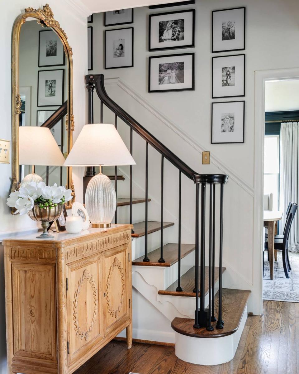 a staircase with a mirror and a lamp on the side