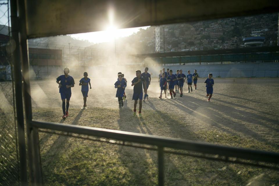 Youths attend soccer training near the area where Nick Samuel Oropeza was killed when anti-government protests broke out the previous week in Caracas, Venezuela, Wednesday, Jan. 30, 2019. Critics say President Nicolas Maduro is hitting back at anti-government protesters by sending security forces into the slums to try to suppress dissent. (AP Photo/Rodrigo Abd)