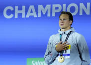 Justin Ress of the United States listens to his national anthem after winning the men's 50m backstroke final at the 19th FINA World Championships in Budapest, Hungary, Saturday, June 25, 2022. (AP Photo/Petr David Josek)