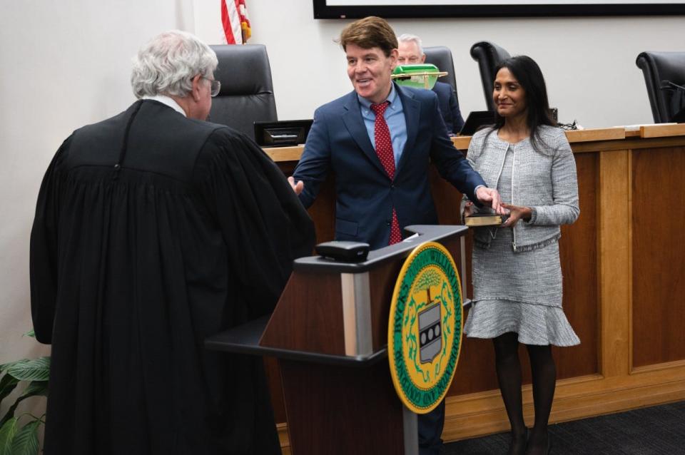 New Bucks County Recorder of Deeds Dan McPhillips receives congratulations from Bucks County President Judge Wallace Bateman as McPhillip's wife, Piyumika, watches during the inaugural ceremony at the county administration building Monday.