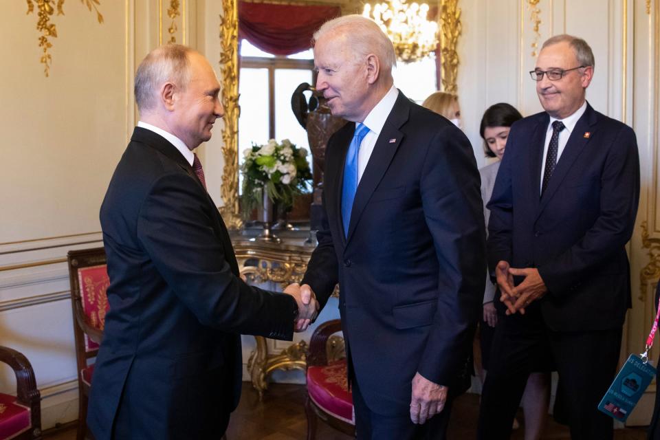 Vladimir Putin shakes hands with Joe Biden during their  summit in Geneva (AP)
