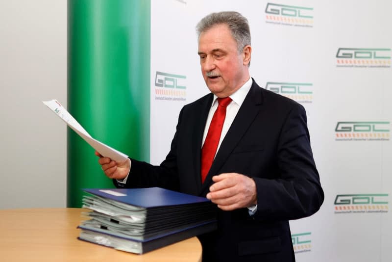 Claus Weselsky, Chairman of the German Train Drivers' Union (GDL), stands at a table with folders of signed collective agreements after a press conference on the agreement reached with Deutsche Bahn in the wage dispute. Carsten Koall/dpa
