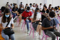 People fill a recovering room after receiving the coronavirus vaccine at a vaccination center in Lisbon, Saturday, Sept. 11, 2021. As Portugal nears its goal of fully vaccinating 85% of the population against COVID-19 in nine months, other countries want to know how it was able to accomplish the feat. A lot of the credit is going to Rear Adm. Henrique Gouveia e Melo. (AP Photo/Armando Franca)