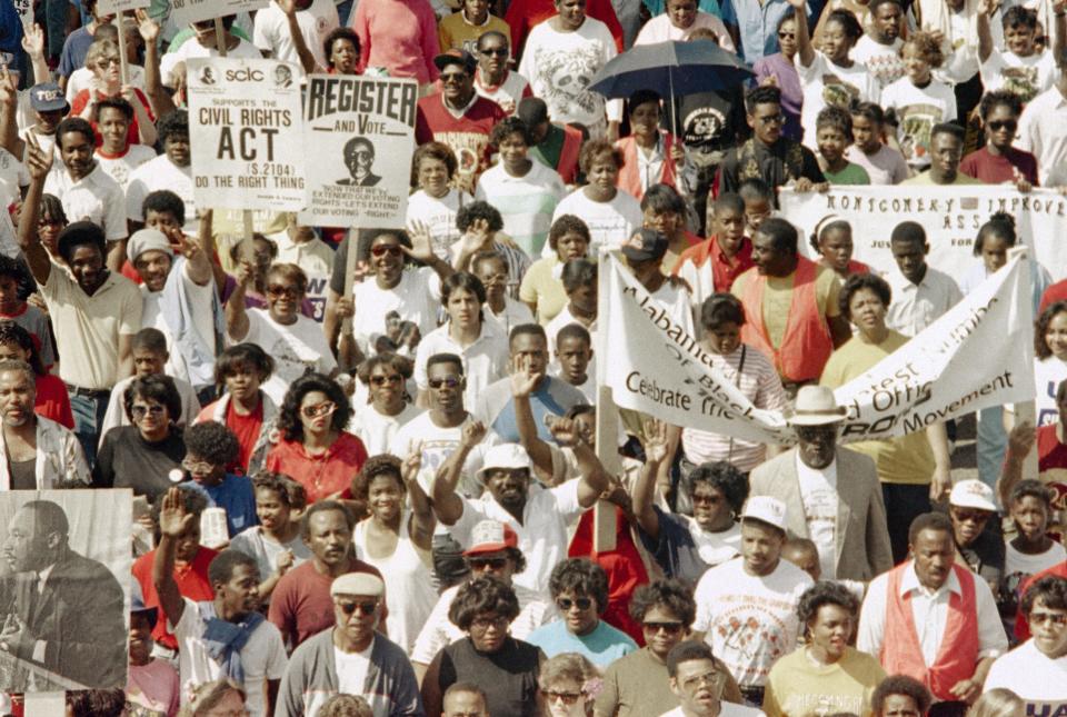 Thousands of demonstrators march to the Alabama Capitol completing the final leg of the 25 anniversary of the 1965 Selma to Montgomery civil rights march in Montgomery on Saturday, March 10, 1990. The marchers began their trek at the Edmund Pettus Bridge in Selma.