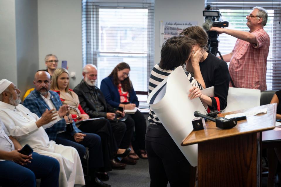 A woman kisses her partner after speaking during public comment before a vote about banning the LGBTQ Pride flag on government buildings and city property, in addition to other flags representing racial and political issues, during a city council meeting at Hamtramck City Hall on Tuesday, June 13, 2023.