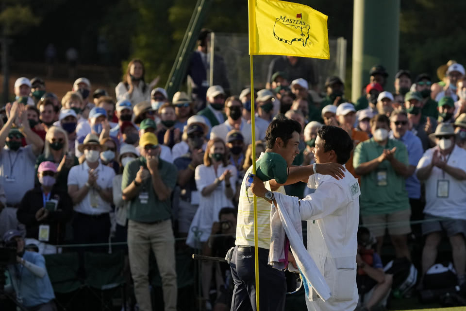 Hideki Matsuyama, of Japan, hugs his caddie Shota Hayafuji after winning the Masters golf tournament on Sunday, April 11, 2021, in Augusta, Ga. (AP Photo/Gregory Bull)