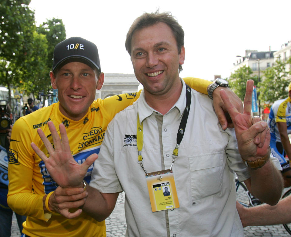 FILE - In this July 24, 2005 file photo, Lance Armstrong, left, and Johan Bruyneel, sporting director of the Discovery team, pose for photographers on the Champs Elysees during a victory parade after Armstrong won his 7th straight Tour de France cycling race in Paris. Armstrong has given sworn testimony naming several people he says knew about his performance-enhancing drug use. He insists he didn't pay anyone or any organization to keep his doping secret. Armstrong says team manager Bruyneel assisted his doping. (AP Photo/Alessandro Trovati, File)