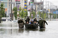 Japan Self Defense Force members rescue residents on a boat on a flooded road hit by heavy rain in Omuta, Fukuoka prefecture, southern Japan Tuesday, July 7, 2020. Rescue operations continued and rain threatened wider areas of the main island of Kyushu. (Juntaro Yokoyama/Kyodo News via AP)