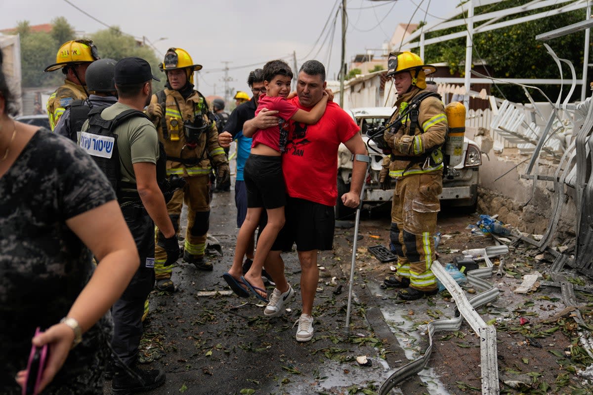 Israelis evacuate a site struck by a rocket fired from the Gaza Strip, in Ashkelon on Monday 9 October  (Copyright 2023 The Associated Press All rights reserved)