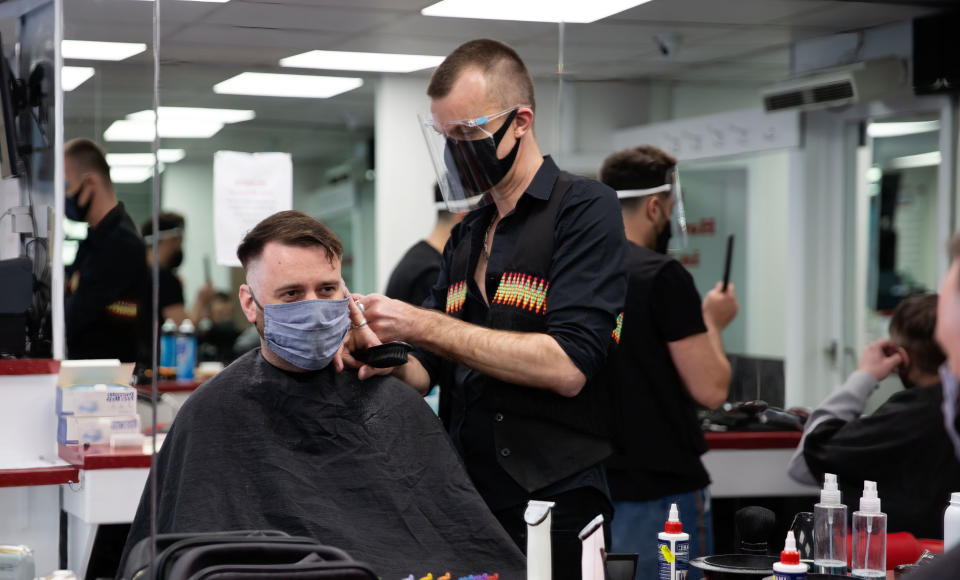  A hairdresser wearing a face mask and shield cuts hair of a client during the reopening.
Shops, restaurants, bars and other businesses reopened today after almost four months as further lockdown rules are relaxed in England. (Photo by Yunus Dalgic / SOPA Images/Sipa USA) 