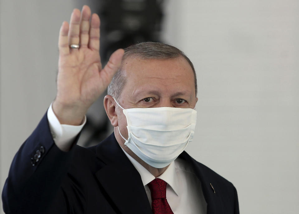 FILE - In this Friday, May 29, 2020, file photo, Turkey's President Recep Tayyip Erdogan, wearing a mask for protection against the coronavirus, arrives to inaugurate a new hospital in Istanbul. When Turkey changed the way it reports daily COVID-19 infections, it confirmed what medical groups and opposition parties have long suspected — that the country is faced with an alarming surge of cases that is fast exhausting the Turkish health system. The official daily COVID-19 deaths have also steadily risen to record numbers in a reversal of fortune for the country that had been praised for managing to keep fatalities low. With the new data, the country jumped from being one of the least-affected countries in Europe to one of the worst-hit.(Can Erok/DHA via AP, File)