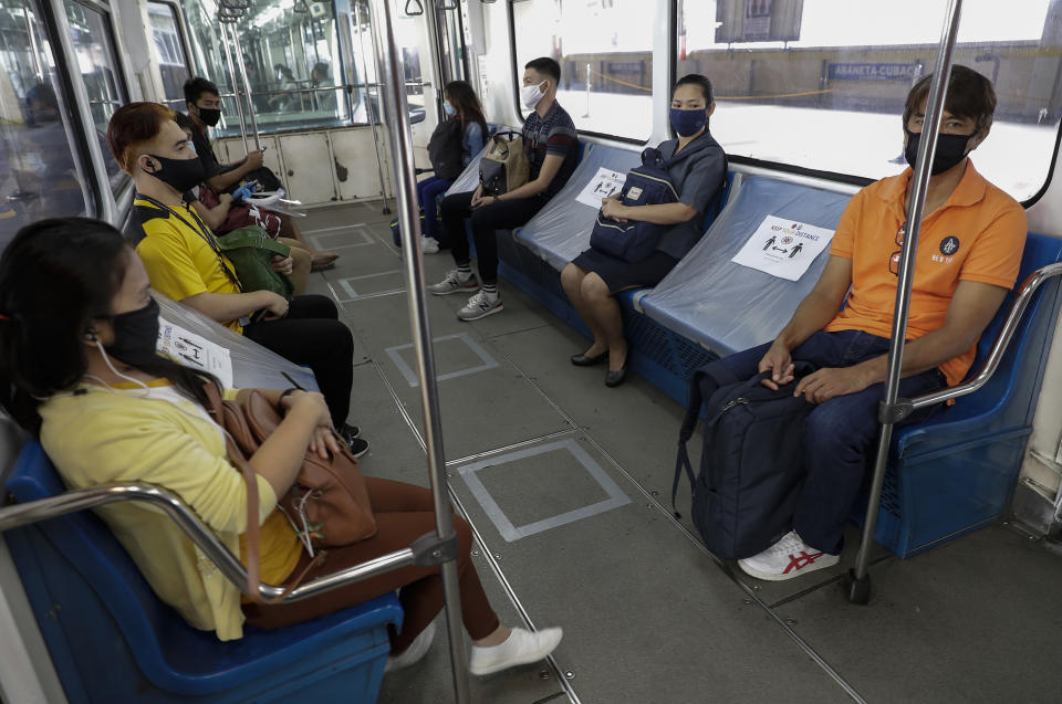 People ride a train with seats arranged for social distancing measures during the first day of a more relaxed coronavirus lockdown in Manila, Philippines on Monday, June 1, 2020. Traffic jams and crowds of commuters are back in the Philippine capital, which shifted to a more relaxed quarantine with limited public transport in a high-stakes gamble to slowly reopen the economy while fighting the coronavirus outbreak. (AP Photo/Aaron Favila)