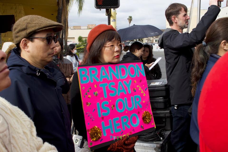 A person holds a sign in support of Brandon Tsay during Alhambra's ceremony at its Lunar New Year festival on Jan. 29, 2023.