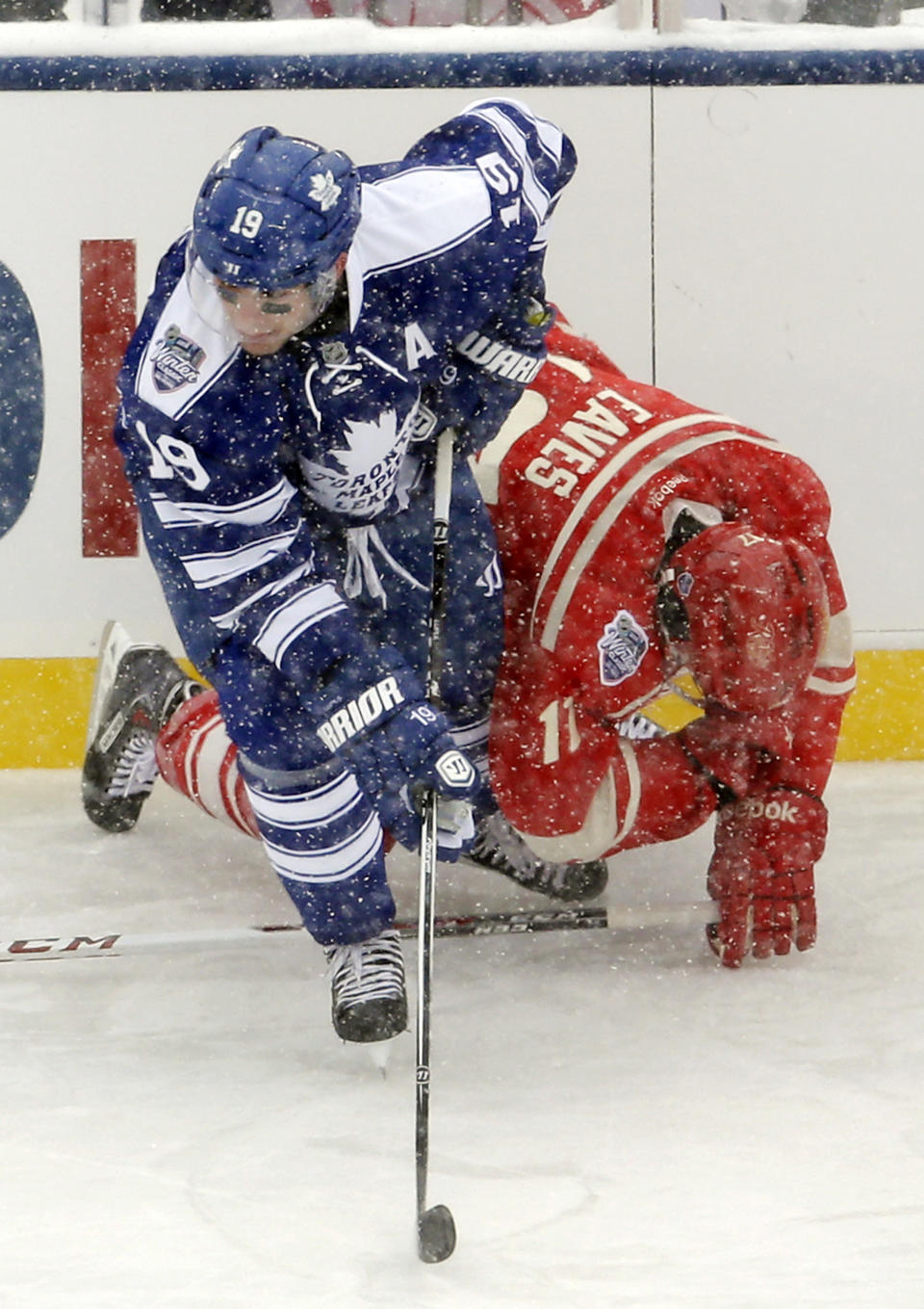 Toronto Maple Leafs right wing Joffrey Lupul (19) skates away after cross-checking Detroit Red Wings forward Patrick Eaves behind the headduring the first period of the Winter Classic outdoor NHL hockey game at Michigan Stadium in Ann Arbor, Mich., Wednesday, Jan. 1, 2014. Lupul received a two-minute penalty, and Eaves left the ice after hit. (AP Photo/Carlos Osorio)