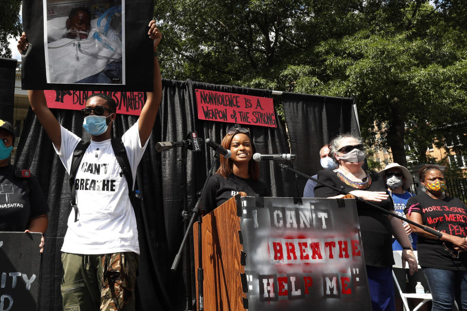 In this June 6, 2020 photograph, Maisie Brown, 18, center, a member of the Mississippi branch of Black Lives Matter, speaks during a rally protesting police brutality in Jackson, Miss. Young activists like Brown are energizing the debate about removing the Confederate battle emblem from the Mississippi state flag. Brown says elected officials must step up and change the flag. (AP Photo/Rogelio V. Solis)