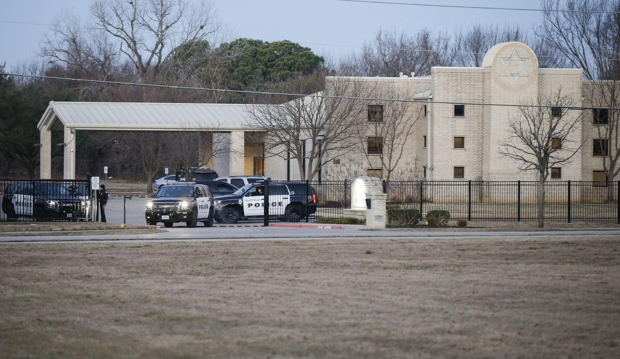 Police stand in front of the Congregation Beth Israel synagogue on Sunday, Jan. 16, 2022, in Colleyville, Texas. A man held hostages for more than 10 hours Saturday inside the temple. The hostages were able to escape and the hostage-taker was killed. FBI Special Agent in Charge Matt DeSarno said a team would investigate "the shooting incident."