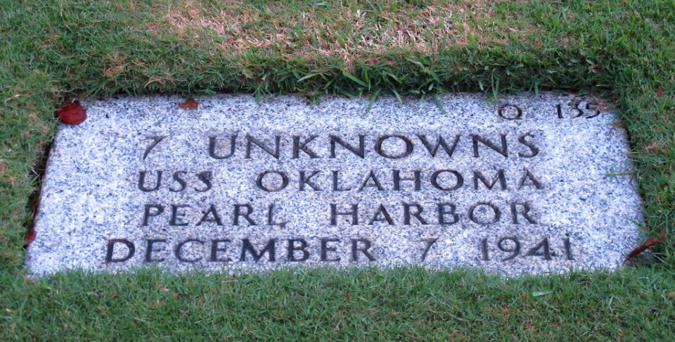 FILE – In this Dec. 5, 2012, file photo, the National Memorial Cemetery of the Pacific in Honolulu displays a gravestone identifying it as the resting place of seven unknown people from the USS Oklahoma who died in Japanese bombing of Pearl Harbor. More than 75 years after nearly 2,400 members of the U.S. military were killed in the Japanese attack at Pearl Harbor some who died on Dec. 7, 1941, are finally being laid to rest in cemeteries across the United States. After DNA allowed the men to be identified and returned home, their remains are being buried in places such as Traer, Iowa and Ontonagon, Michigan. (AP Photo/Audrey McAvoy, File)