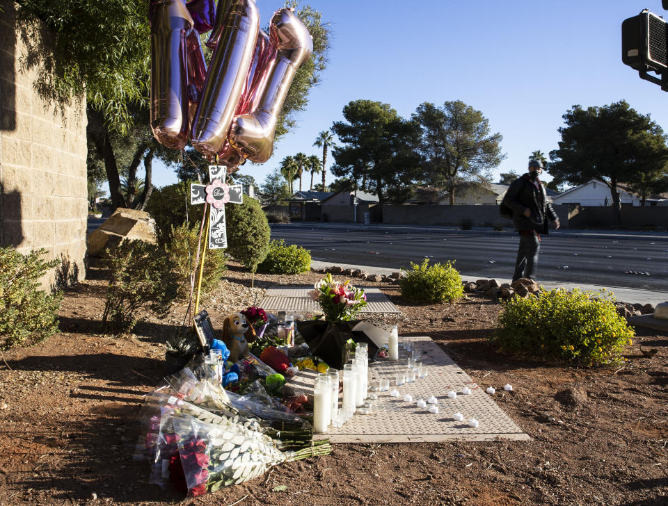 A pedestrian walks past a makeshift memorial to honor Tina Tintor, 23, at South Rainbow Boulevard and Spring Valley Parkway, on Thursday, Nov. 4, 2021, in Las Vegas. Tintor and her dog were killed when former Raiders wide receiver Henry Ruggs, accused of DUI, slammed into the rear of Tintor's vehicle. (Bizuayehu Tesfaye/Las Vegas Review-Journal)