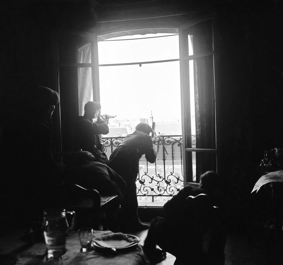 FILE - This Aug. 26, 1944 file photo shows members of the French Forces of the Interior (FFI) shoot at German snipers from a window in Paris. The fighting for the liberation of Paris took place from August 19 to August 25, 1944. (AP Photo/Peter J. Carroll, File)