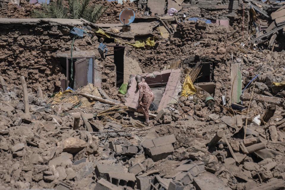 A woman tries to recover some of her possessions from her home which was damaged by an earthquake in the village of Tafeghaghte, near Marrakech, Morocco, Monday, Sept. 11, 2023. Rescue crews expanded their efforts on Monday as the earthquake’s death toll continued to climb to more than 2,400 and displaced people worried about where to find shelter. | Mosa’ab Elshamy, Associated Press