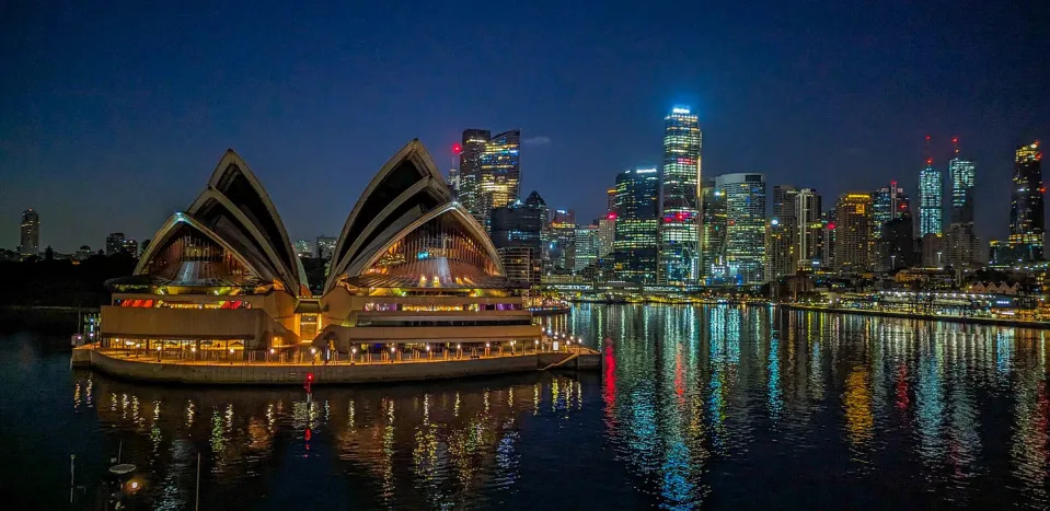The Sydney Opera House and the city skyline lit up at night