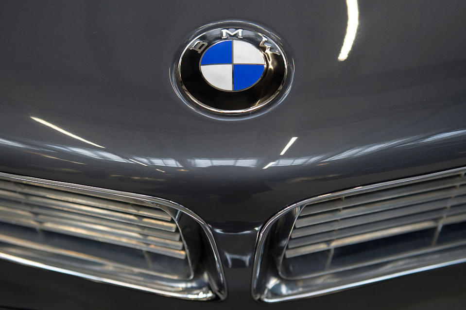 Close-up of a BMW car hood showing the BMW logo and part of the car's front grill, highlighting luxury in automotive design